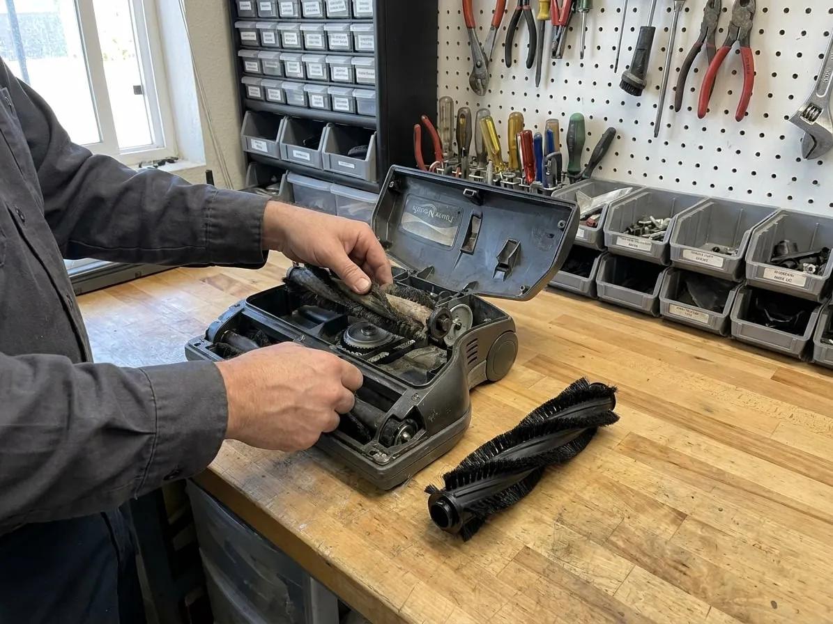 Technician replacing the brush roll in a Rainbow power nozzle